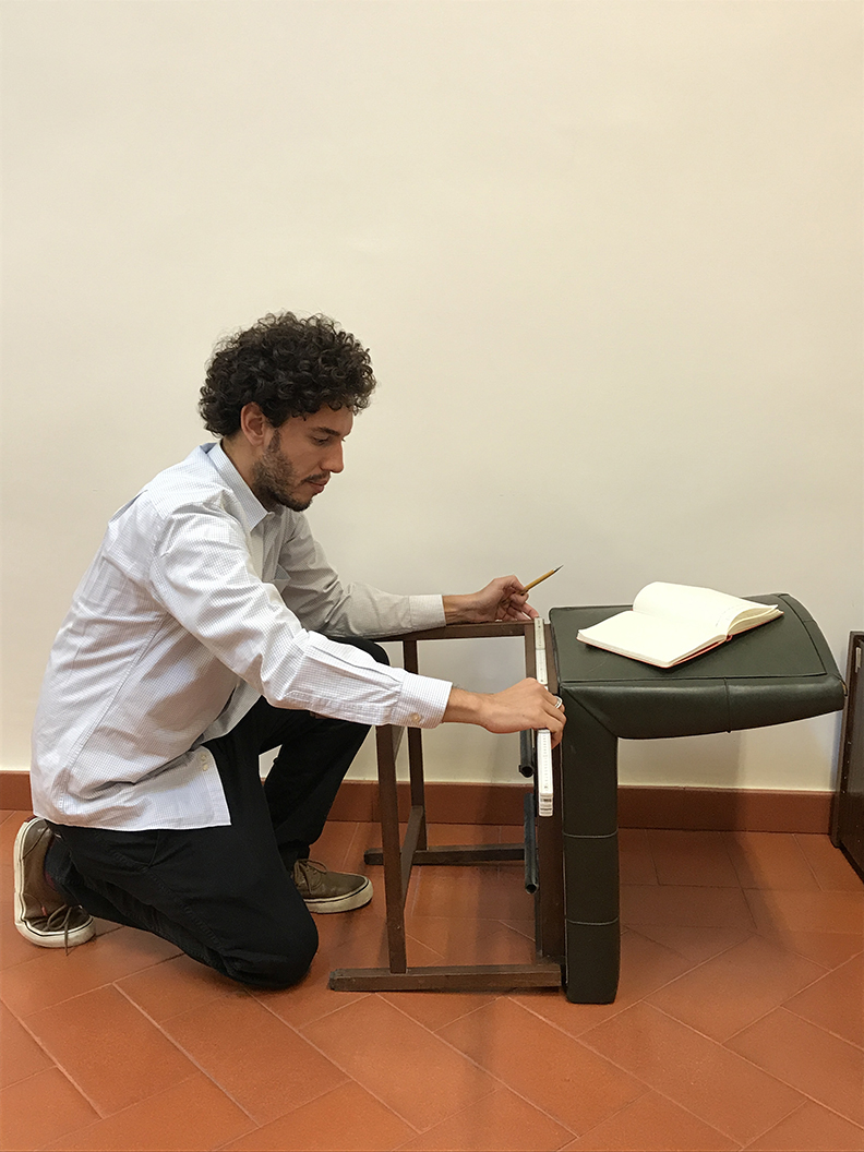 Pesquisador do Instituto Sergio Rodrigues, Dimitri Buriti, medindo a Cadeira Chancelaria
